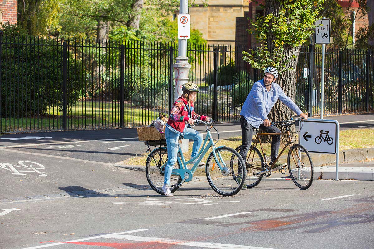 Two cyclists using the widenend bike lanes on College Crescent.
