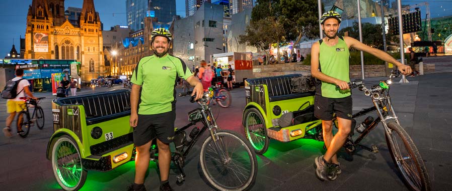 Two bike taxis and riders at Federation Square