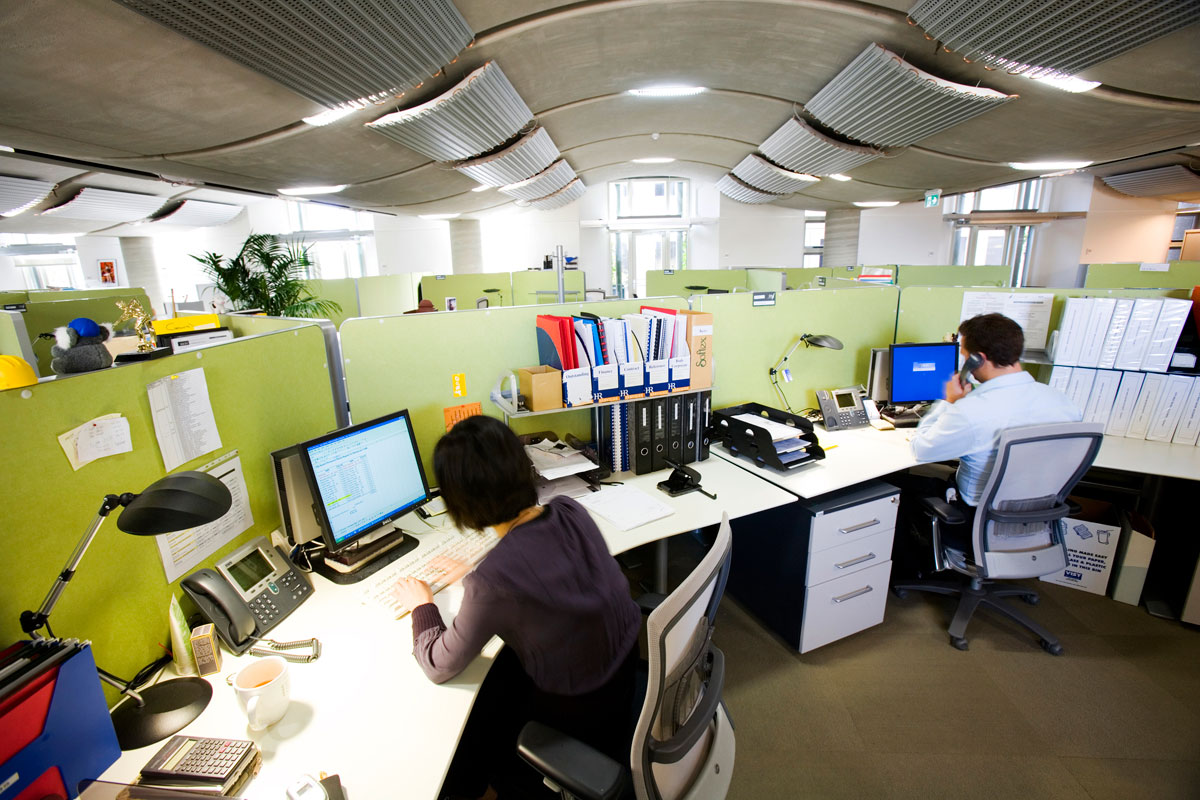Two workers seated at their desks in an office space.
