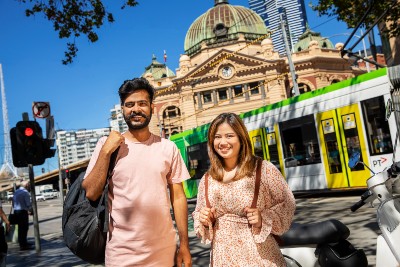 Two people standing in front of Flinders Street Station.