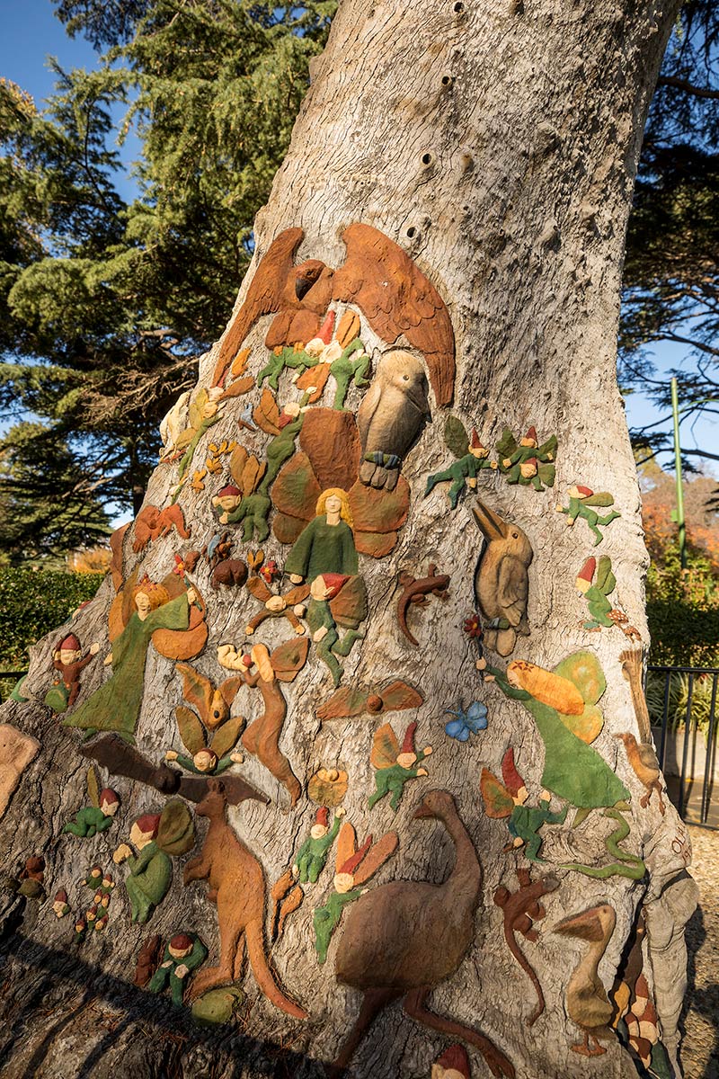The Fairies’ Tree sculpture, comprising coloured fairies, elves and various Australian animals carved into the base of a tree stump.