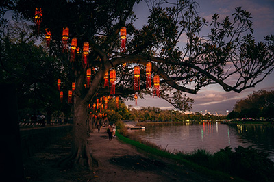 Paper lanterns over river at sunset