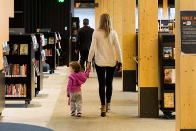 A woman and child walking through a library