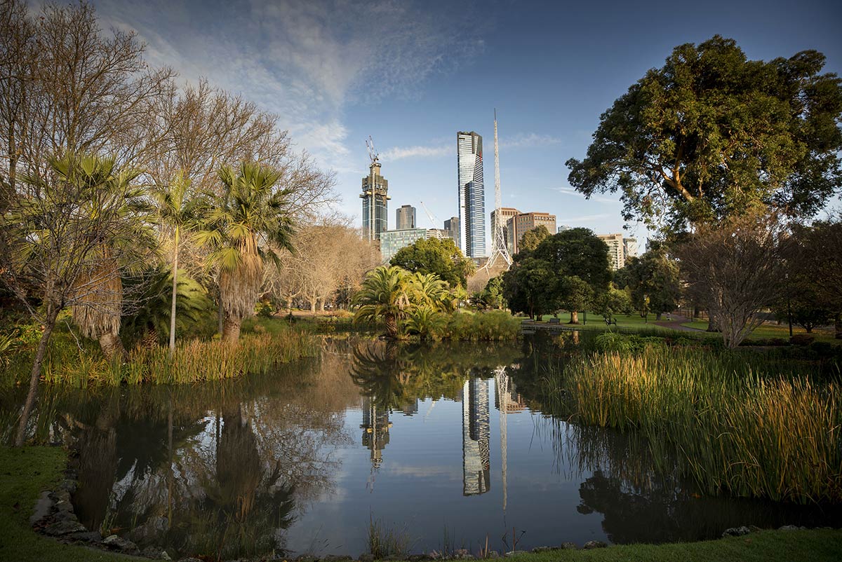 The Eureka Tower and Arts Centre are reflected in the lake in Queen Victoria Gardens.