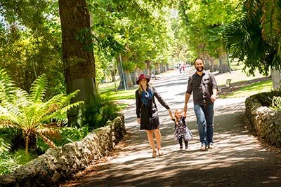 Woman, man and child walking in city park