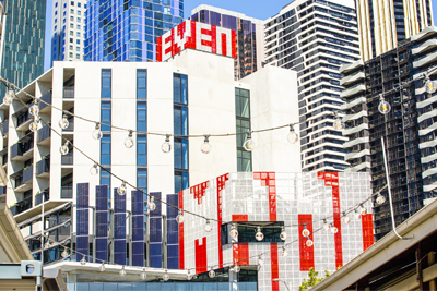 Public artwork with the word 'MORE' on the building facade in white with red background.
