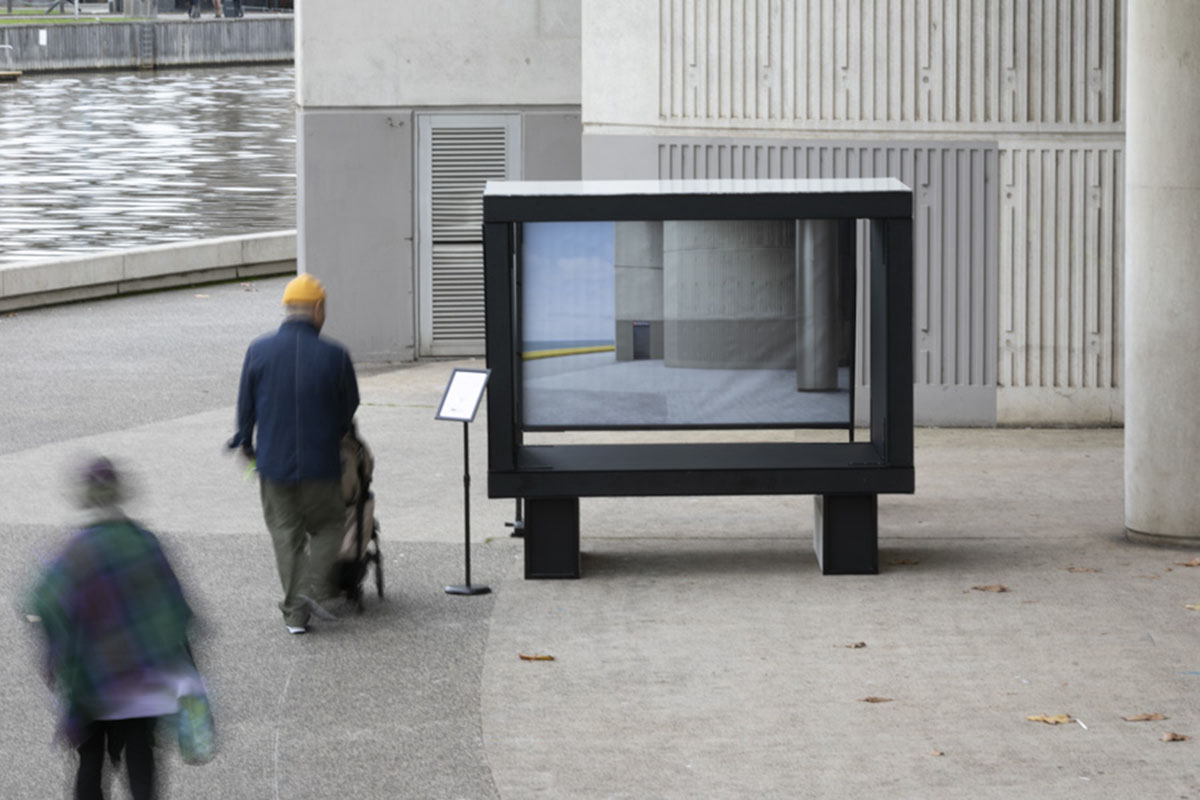 Large tv screen on walkway by river