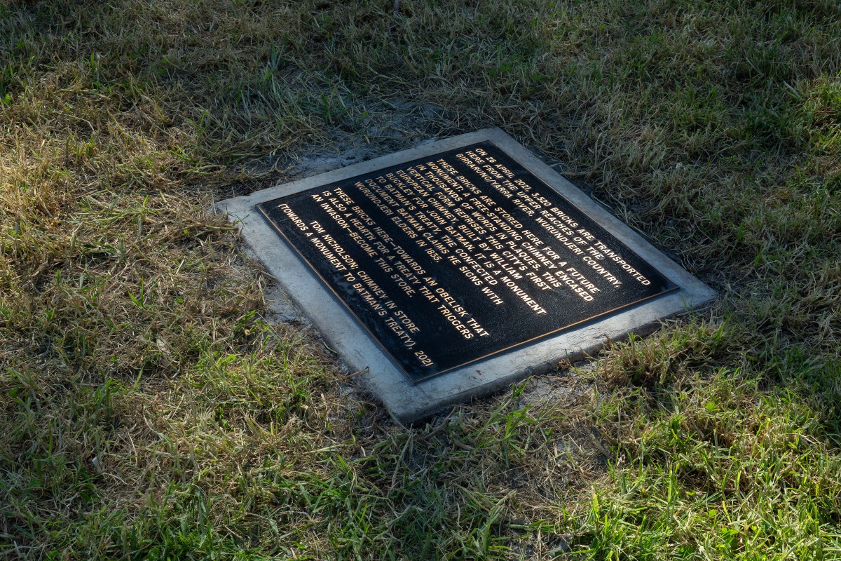 A bronze plaque laid in the grass.